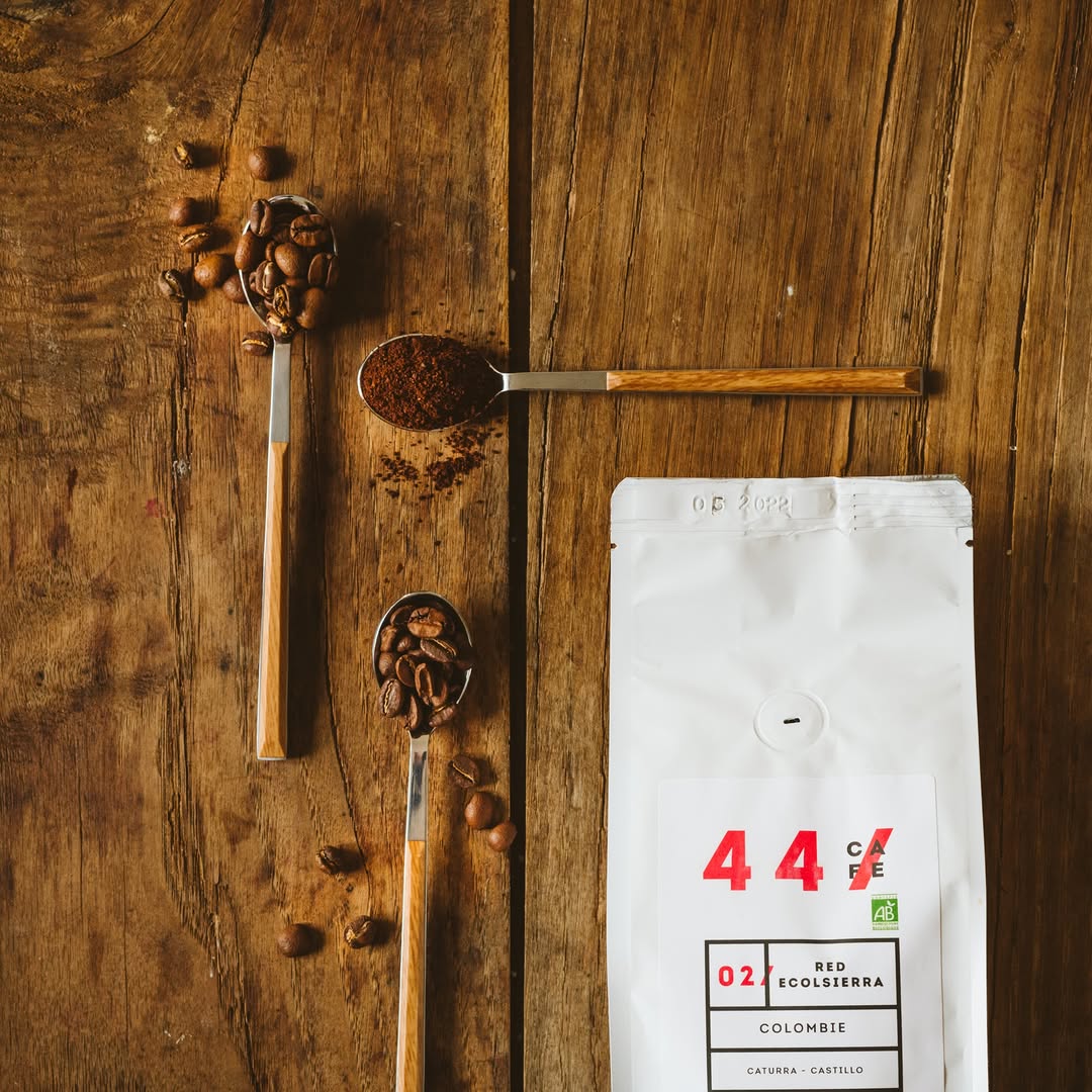 Cuillère de grains de café à côté d'un paquet 44Café Red Ecolsierra bio