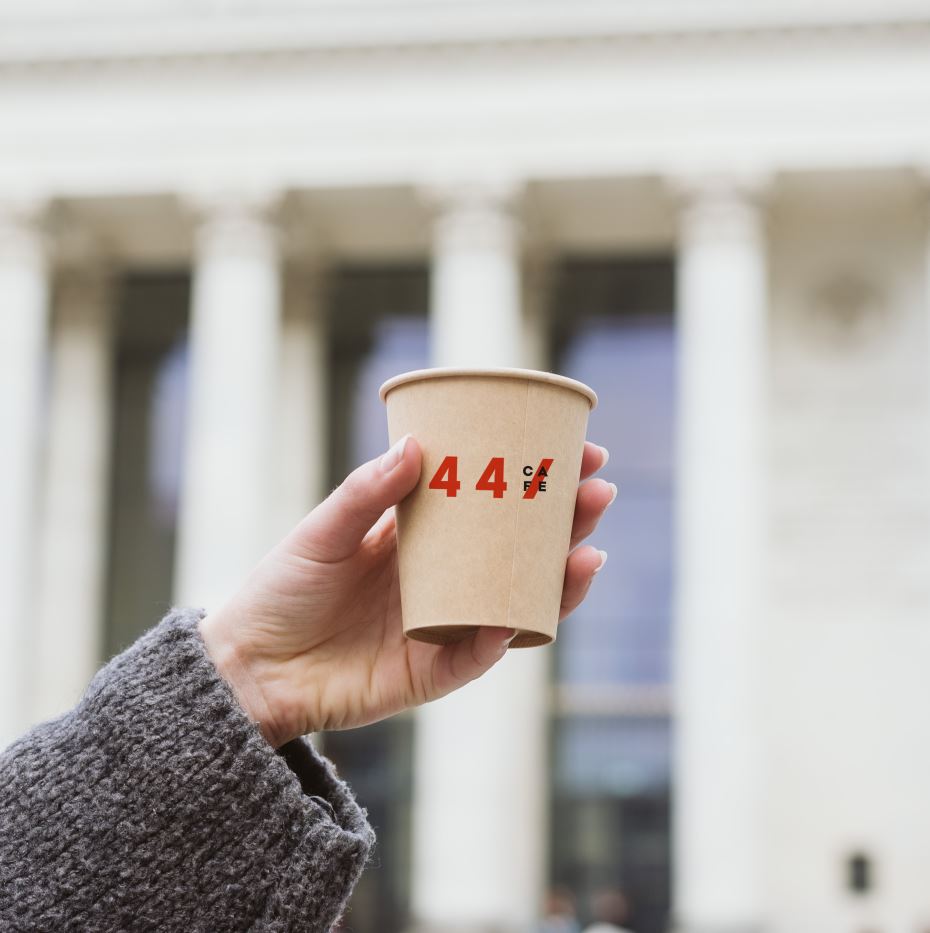 Gobelet en carton 44Café tenu devant un bâtiment à colonnades